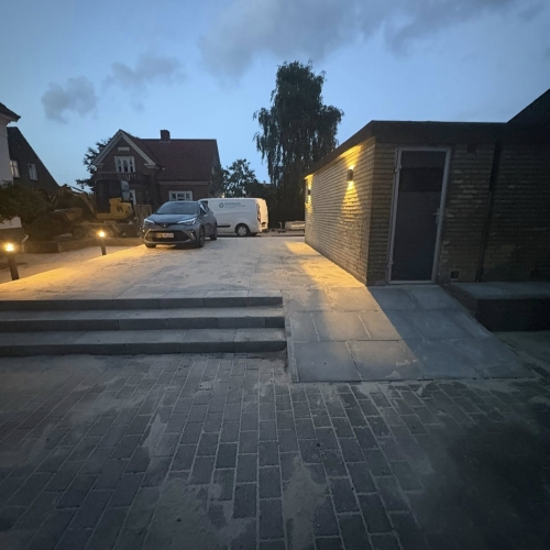 Oversigtsbillede af brolagt gårdsplads og indkørsel udført af brolægger i Bramming.