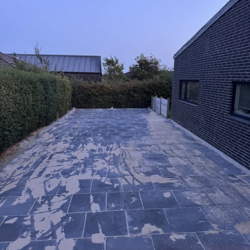Nylagt belægning af indkørsel med fliser og fugesand.