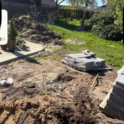 Haveanlæg i Ribe med jordarbejde og fliser stablet til anlæg af ny græsplæne.