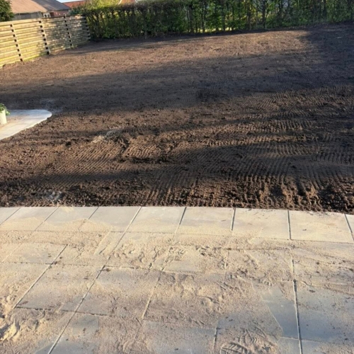 Haveanlæg i Ribe med planeret jord og flisekant klar til ny græsplæne.