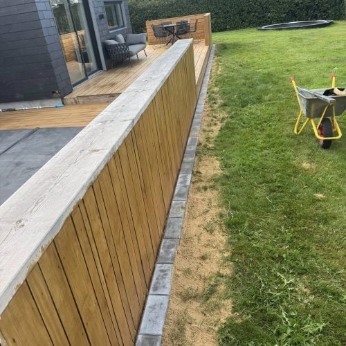 Flisearbejde med præcis flisekant ved terrasse og græsplæne.