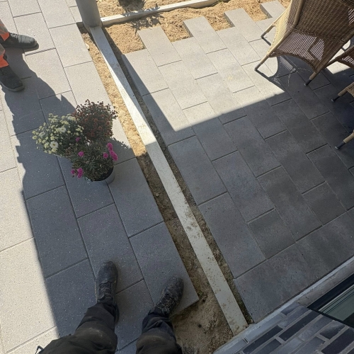 Flisearbejde hvor nye fliser lægges omkring terrasseområde i Bramming.