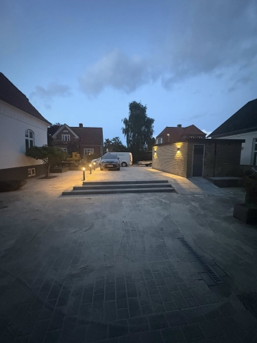 Stor indkørsel med nylagt brolægning og belysning ved trin, Bramming.