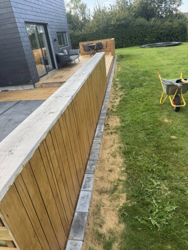 Flisearbejde med præcis flisekant ved terrasse og græsplæne.