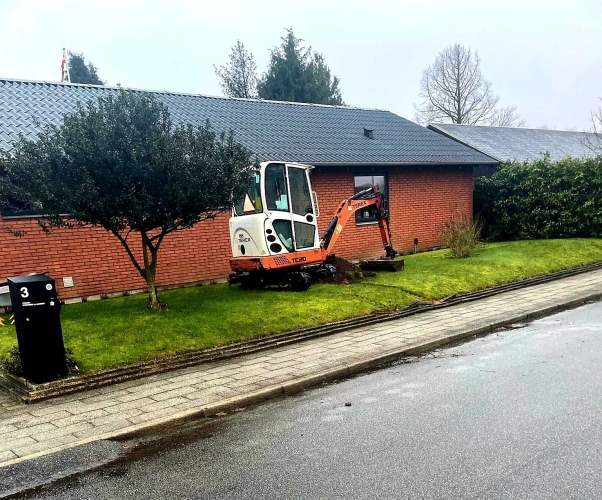 Gravemaskine klargør området til belægning af indkørsel med fliser i Gørding.