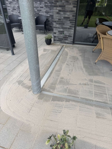 Færdigt flisearbejde med sandfyldning mellem fliser på terrasse i Bramming.