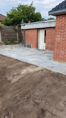 Flisearbejde med ny fliseterrasse ved garage og have.