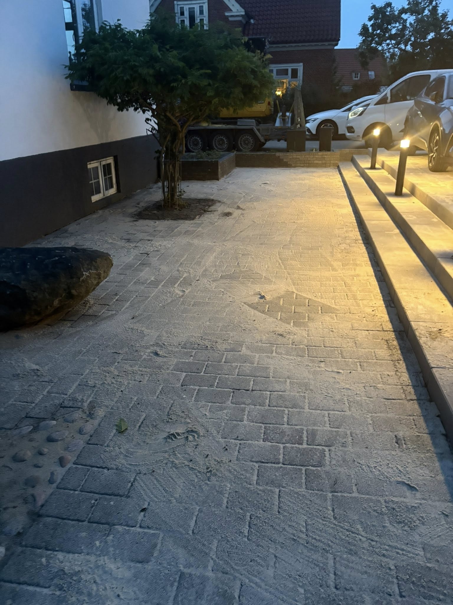 Ny brolægning af indkørsel med lys langs kantsten udført af brolægger i Bramming.