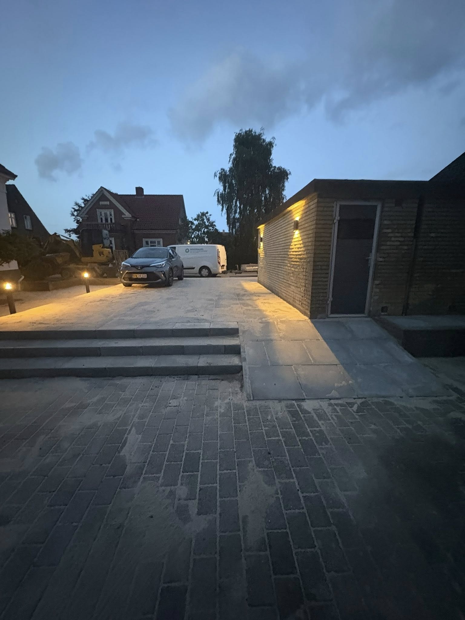 Oversigtsbillede af brolagt gårdsplads og indkørsel udført af brolægger i Bramming.