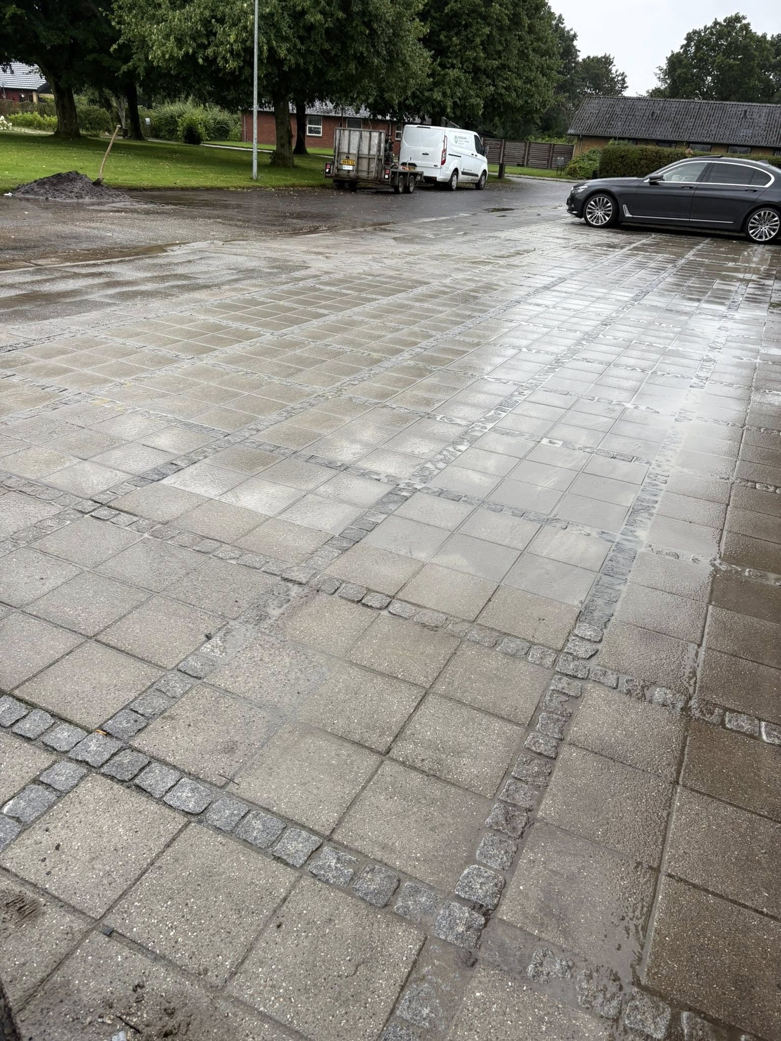 Ny brolægning af indkørsel med kvadratiske fliser udført af brolægger i Esbjerg.