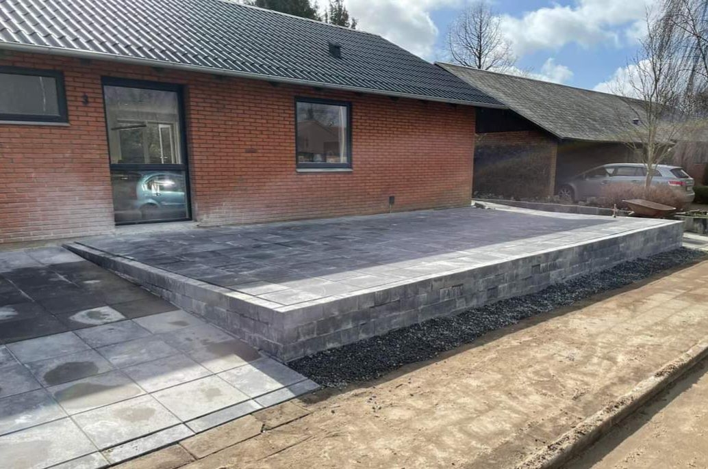 Hævet terrasse med flot ny flisebelægning ved indkørsel i Gørding.